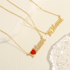 Close-up of gold MAMA necklace with red enamel heart and sparkling zircon inlay