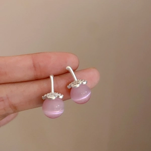 Dettaglio degli orecchini in opale rosa con accenti floreali in argento e zirconi lucenti