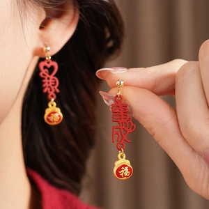 Detail of vintage red enamel tassel earrings with Chinese Fu character and gold accents