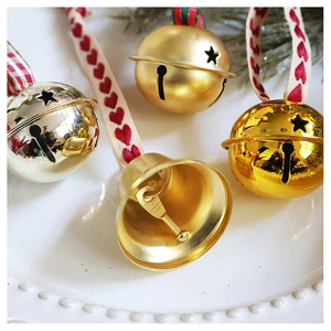 Close-up of champagne star cutout bells with red heart ribbons on a festive tray