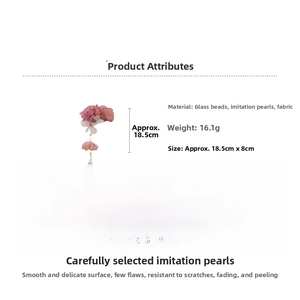 Vue détaillée d'une pince à cheveux florale avec pétales en soie et pompons perlés
