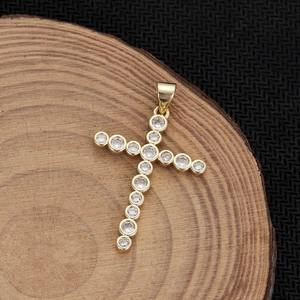 Dettaglio del ciondolo a croce placcato oro 18K con zirconi su base in legno