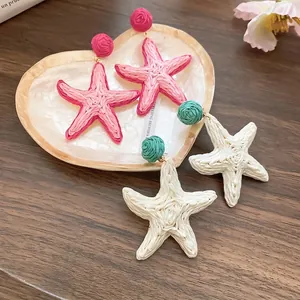 Handcrafted raffia starfish drop earrings in pink and beige for beach vacation style