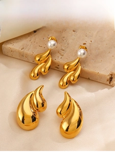 Detail of 18K gold plated teardrop earrings with pearls on champagne silk background