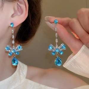 Detailed shot of long silver tassel earrings with blue zircon water drop charms