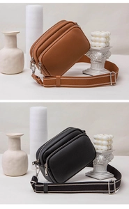 Close-up of litchi texture leather crossbody bags with triple zippers and wide straps
