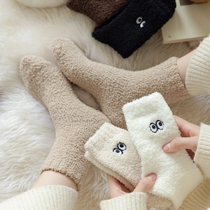 Detail of coral fleece thermal socks featuring cute embroidered eye patterns in four colors