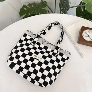Lace-trimmed checkered canvas tote bag with Korean design label on white tabletop