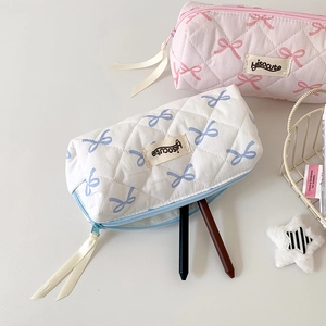 Quilted cotton pencil case with pink bow print and ribbon zipper detail in macro view