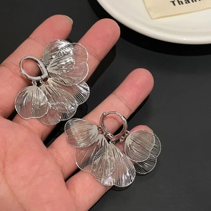 Handheld silver fan-shaped hollow metal petal earrings with elegant metallic texture