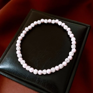Close-up of pink pearl bracelet with pavé crystal balls on a luxury black jewelry box