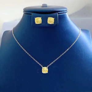 Detailed set of yellow cushion-cut diamond jewelry on dark blue display mannequin