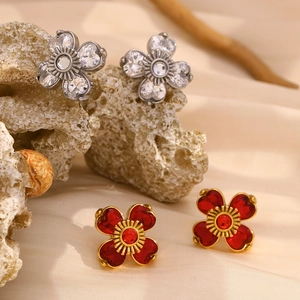 Détail de boucles d'oreilles fleur aux pétales de cœur en or rouge et argent blanc