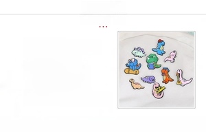 Macro detail of zinc alloy cartoon dinosaur brooches with plating and oil drip finish