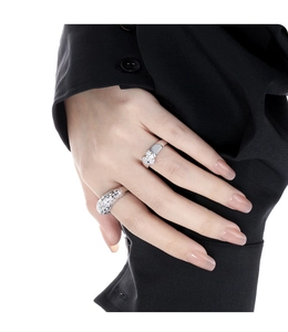 Detailed close-up of textured wide silver band and heart-shaped inlay ring on model hand