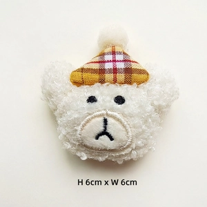 Detail of plush bear head accessory with plaid hat and size specs H6cm x W6cm