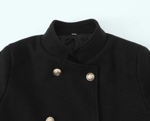Close-up of stand-up collar and gold embossed lion head buttons on black wool coat