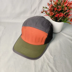 Detail of a 5-panel camper hat featuring multi-color blocking and outdoor street style