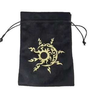Close-up of black velvet drawstring pouch with golden sun totem print for tarot cards