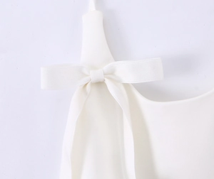 Close-up of white halter top showing detailed bow tie knot and fine fabric texture
