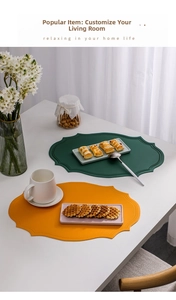 Detail of dark green and yellow oval leather placemats with embossed borders and heat resistance