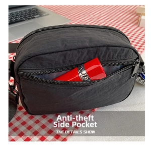 Detail view of anti-theft side pocket on black nylon bag with a lipstick inside