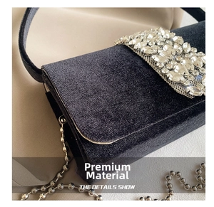 Detail of black velvet evening bag with sparkling rhinestone buckle and silver bead chain
