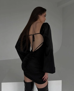 Detailed back view of a black ruched bodycon dress with lace-up open back design