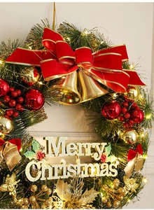Detail of luxury Christmas wreath with red bow, golden bells, and Merry Christmas sign