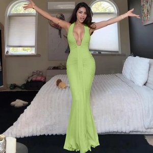 Détail d'une robe longue verte froncée avec col en U et ourlet sirène moulant élégant