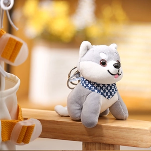 Close-up of mini husky plush keychain with floral scarf on wooden handle