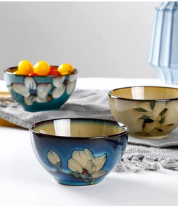 Close-up of three Japanese style ceramic bowls with floral patterns in blue and beige