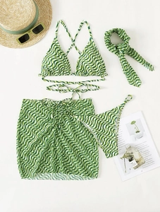 Flat lay of a green and white wave pattern bikini set with matching skirt and headband