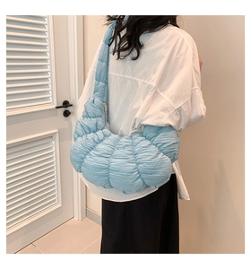 Close-up of light blue pleated dumpling bag showing soft texture and metal zipper detail