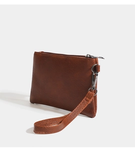 Detailed view of brown PU leather pouch with litchi texture and detachable wrist strap