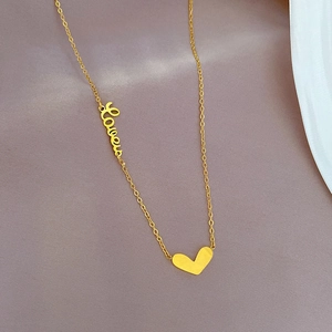 Dettaglio della collana in acciaio al titanio dorato con ciondolo Love e cuore