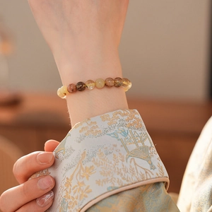 Détail d'un bracelet en quartz rutilé coloré porté sur le poignet d'une femme