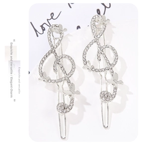 Detailed shot of treble clef hair pins with silver alloy diamonds and butterfly charms