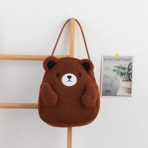 Detail of plush teddy bear shoulder bag in brown sherpa fabric with embroidered face