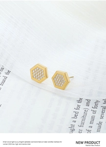 Macro shot of gold plated titanium steel hexagonal stud earrings with cubic zirconia pavé