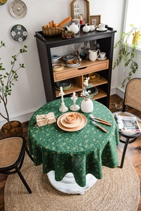 Detail of Christmas green tablecloth with gold foil snowflakes and bells on cotton fabric