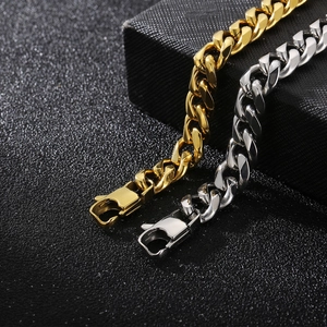 Chaînes gourmettes minimalistes en acier doré et argenté sur une boîte à bijoux en cuir