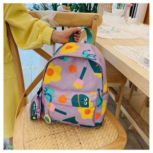 Detail of purple children backpack with floral patterns and a matching round coin purse
