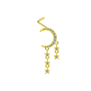 Détail d'un piercing de nez doré avec croissant de lune brillant et étoiles pendantes