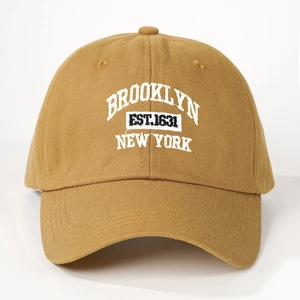 Detailed close-up of Brooklyn New York white embroidery on a khaki cotton baseball cap