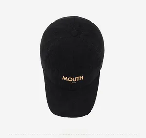 Top view of black corduroy baseball cap with MOUTH embroidery on smooth white background