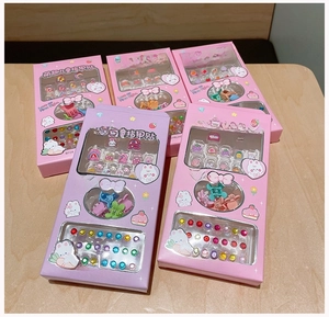 Kids cartoon nail stickers set with colorful hair clips and decorative gems in pink boxes