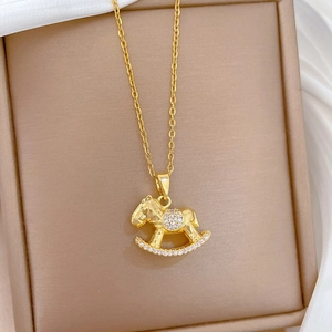Detailed close-up of a golden rocking horse pendant featuring sparkling pavé crystals