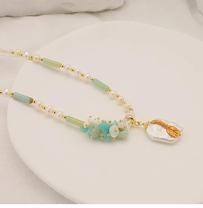 Detail of baroque pearl and amazonite square pendant on a long beaded necklace