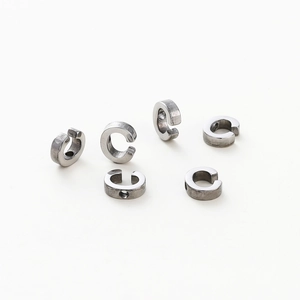 Close-up of silver-plated DIY alphabet charms with 1.8mm holes on white background